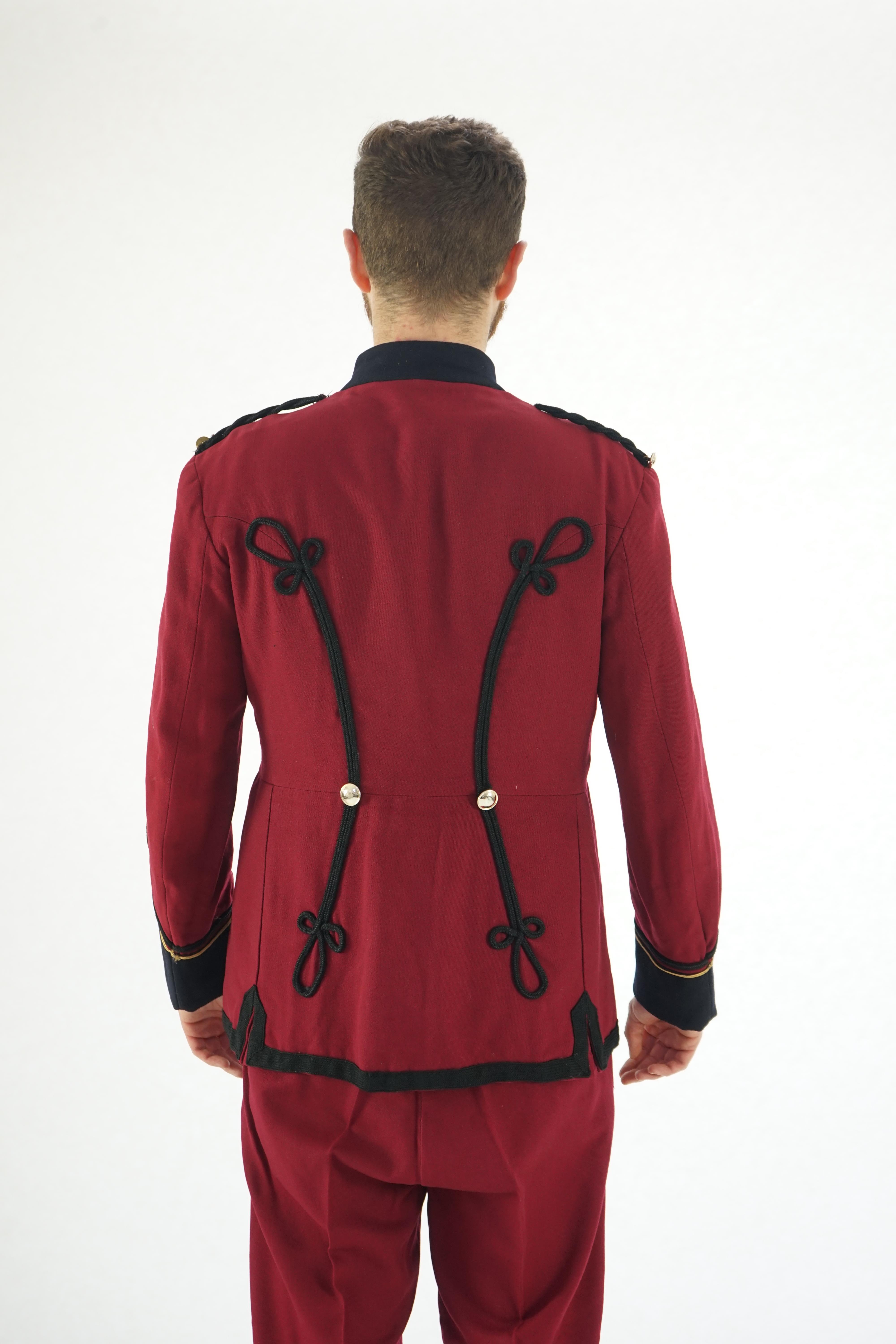 An early 20th century burgundy and black trim Military/Bandsman's uniform jacket and trousers.